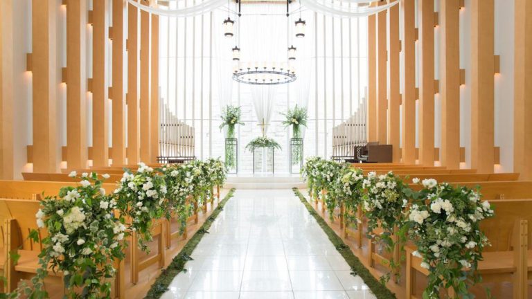 An outdoor crystal chapel with a large window behind the altar, beyond which a waterfall flows